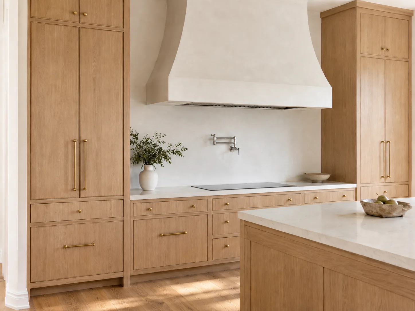 Natural wood kitchen cabinets with visible grain beside light stone counters